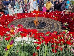 Гатчинцы идут почтить память погибших к Вечному огню на Мемориальном комплексе Мирным жителям